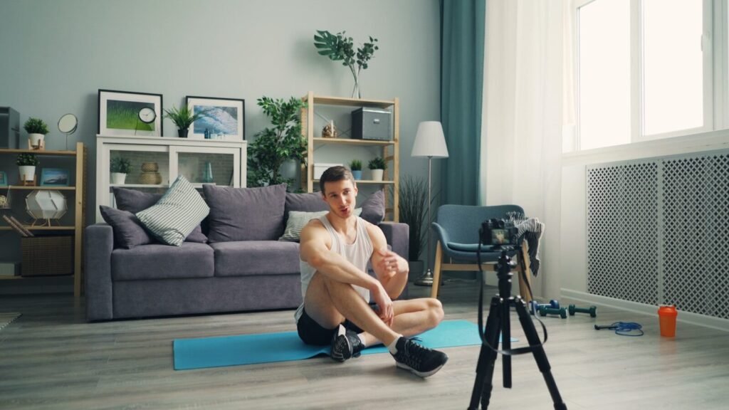 a man sitting on a yoga mat in front of a camera